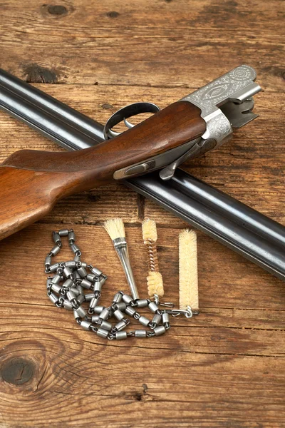 Pistola da caccia con kit di pulizia su un tavolo di legno — Foto Stock