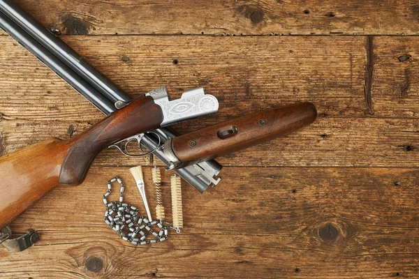 Lovecké zbraně s čistící sada na dřevěný stůl — Stock fotografie