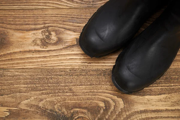 Botas impermeables de plástico sobre un suelo de madera — Foto de Stock