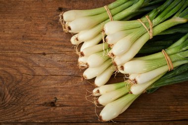 Ahşap mutfak masasında taze soğan