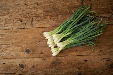 Ahşap mutfak masasında taze soğan