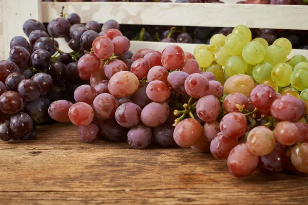 Bunch of fresh grapes on wooden kitchen bench — Stock Photo, Image