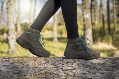 Doğada ormanda yürüyen bir insan. Sağlıklı bir yaşam tarzı. Ön planda botlar