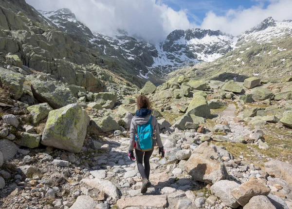 Güneşli bir günde sırt çantalı bir adam dağdan aşağı iniyor. Circo de Gredos, Castilla y Leon, İspanya Milli Parkı.