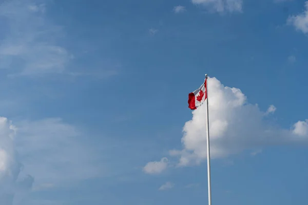 Drapeau du Canada contre ciel bleu nuageux. Vu de loin — Photo