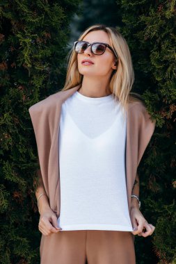 Beyaz tişört ve gözlük takan şık sarışın kız.