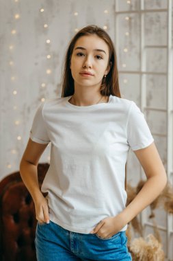 Stüdyoda beyaz tişört ve güneş gözlüğü takan şık bir kız.