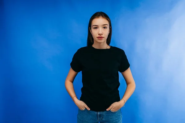 Elegante Chica Con Camiseta Negra Posando Estudio Sobre Fondo Azul — Foto de Stock