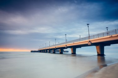 Beton iskelesi Kolobrzeg, gün batımında atış uzun pozlama