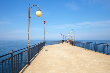 Miedzyzdroje, Polonya - 09 Nisan 2016: Miedzyzdroje beton bir iskele üzerinde yürüyen insanlar. Kasaba ve bir tatil beldesi Polonya Wolin Island üzerinde