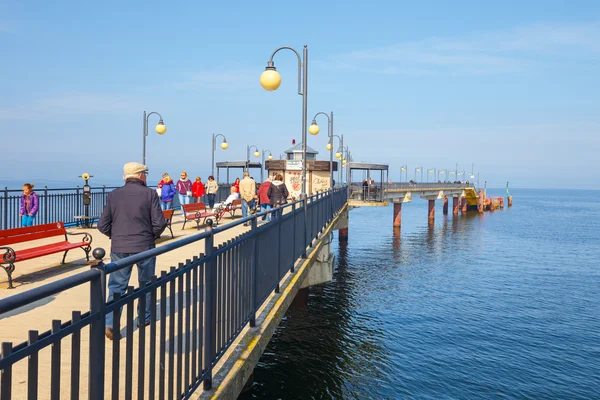 Miedzyzdroje, polen - 09. April 2016: Menschen gehen auf einem Betonpfeiler in miedzyzdroje. Stadt und Badeort in Polen auf der Insel Wolin — Stockfoto