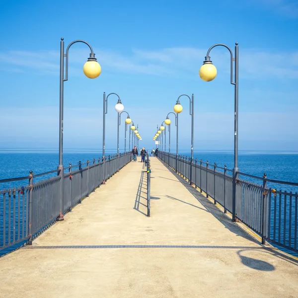 Miedzyzdroje, Polen - 09 April 2016: Mensen lopen op een betonnen pier in Miedzyzdroje. Stad en een badplaats in Polen op het eiland Wolin — Stockfoto