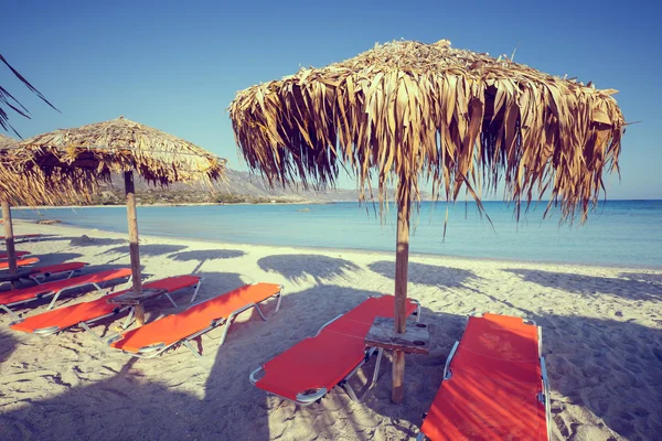 Sun umbrellas and chairs on beach, vintage look — Stock Photo, Image