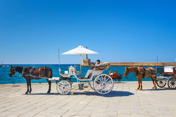Chania, Creta - 23 Maj, 2016: Carruaje de caballos para el transporte de turistas en el antiguo puerto de Chania en Creta, Grecia. Chania es la segunda ciudad más grande de Creta y una ciudad muy popular visitada por los turistas —  Fotos de Stock