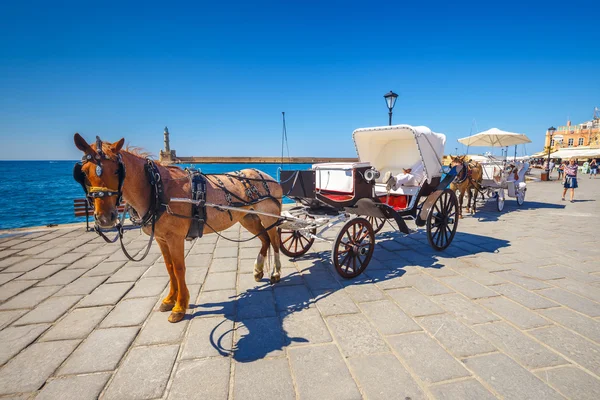 Chania, Crete - 23 Maj, 2016: Horse carriage for transporting tourists in old port of Chania on Crete, Greece. Chania is the second largest city of Crete and and a very popular city visited by tourist Royalty Free Stock Images