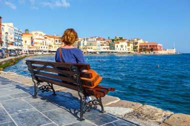 bankta oturan ve eski liman Hanya, Girit, Yunanistan bakarak genç kadın