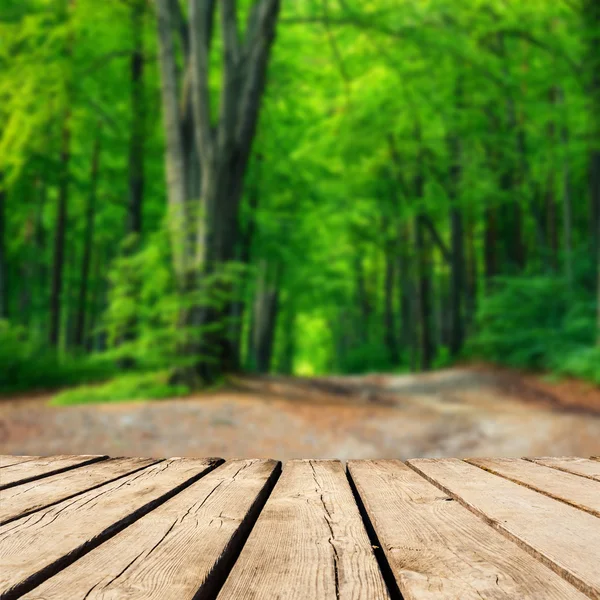 Sfondo sfocato della foresta autunnale e tavolo ponte di legno marrone. Esposizione pronta per il montaggio del prodotto — Foto Stock