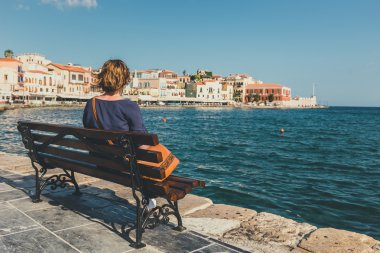 bankta oturan ve eski liman Hanya, Girit, Yunanistan bakarak genç kadın