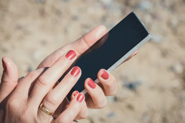 Fechar de uma mulher usando telefone inteligente móvel — Fotografia de Stock