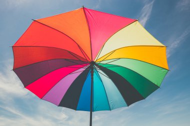 Mavi gökyüzü arka plan, vintage bir görünüm açık renkli gökkuşağı şemsiyesi