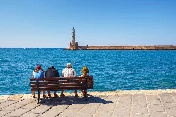 Chania, Creta - 23 Maj, 2016: personas sentadas en el banco en el antiguo puerto de Chania en Creta, Grecia. Chania es la segunda ciudad más grande de Creta . —  Fotos de Stock