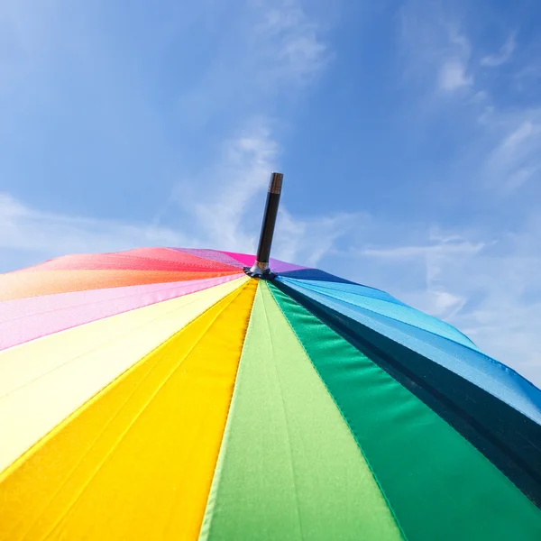 Parapluie arc-en-ciel ouvert coloré sur fond bleu ciel — Photo