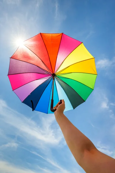 Parapluie arc-en-ciel ouvert coloré sur fond bleu ciel, look vintage — Photo