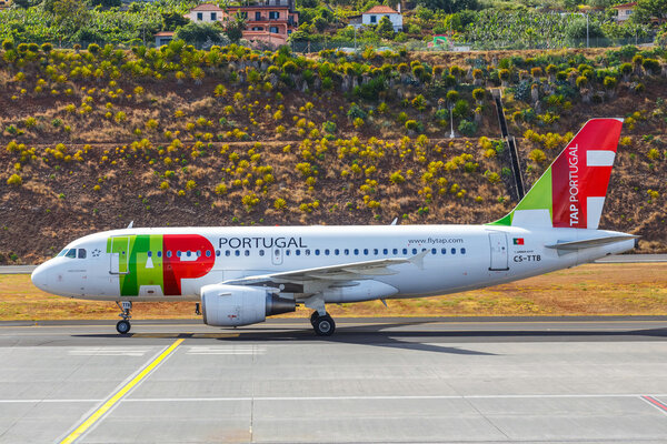 Funchal, Madeira - July 6, 2016: TAP Portugal Airbus A319-111 lands at Funchal Cristiano Ronaldo Airport.This airport is one of the most dangerous airports in Europe