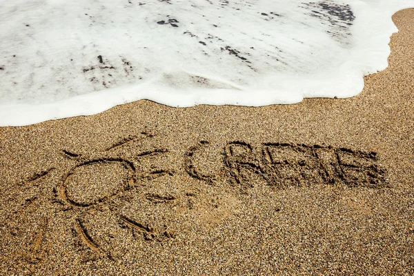 Crete inscription on the sand near the sea — Stock Photo, Image