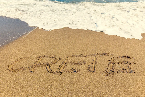 Crete inscription on the sand near the sea — Stock Photo, Image