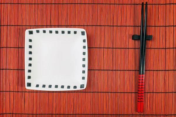 Two chopsticks on sushi mat background — Stock Photo, Image