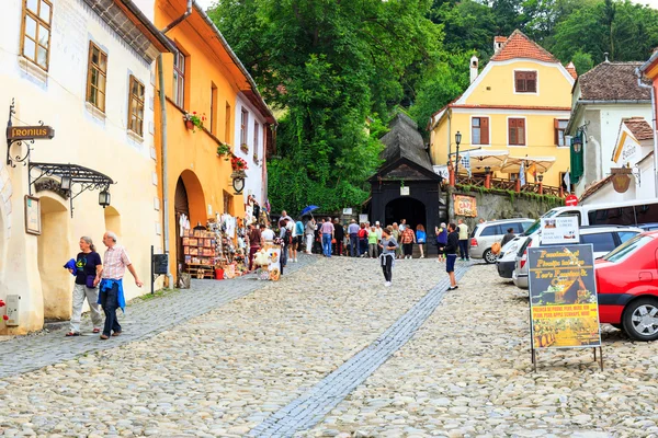 SIGHISOARA, ROMANIA - JULY 17: Unidentified tourists walking in historic town Sighisoara on July 17, 2014. City in which was born Vlad Tepes, Dracula — Stock Photo, Image