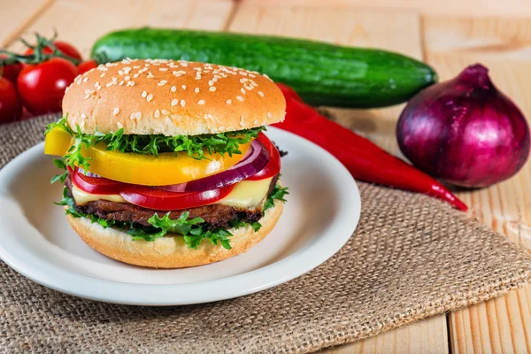 Homemade hamburger with fresh vegetables on cutting board — Stock Photo, Image