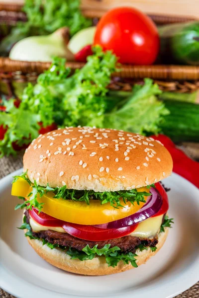 Hamburguesa casera con verduras frescas en la tabla de cortar — Foto de Stock