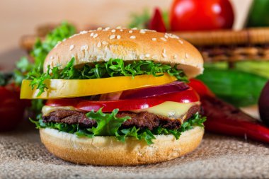 huisgemaakte hamburger met verse groenten op snijplank