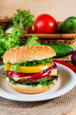 huisgemaakte hamburger met verse groenten op snijplank