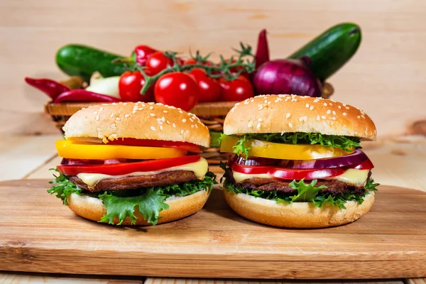 Homemade hamburger with fresh vegetables on cutting board — Stock Photo, Image