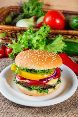 huisgemaakte hamburger met verse groenten op snijplank