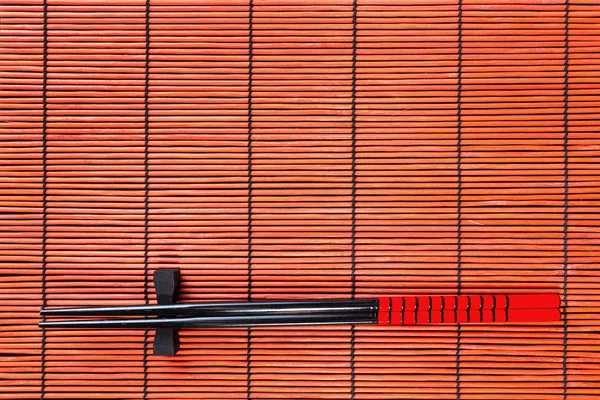 Twee stokjes op sushi mat achtergrond — Stockfoto