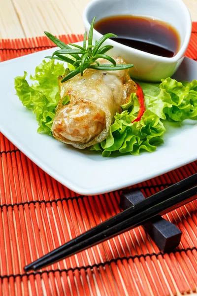 Fried spring rolls on red bamboo mat — Stock Photo, Image