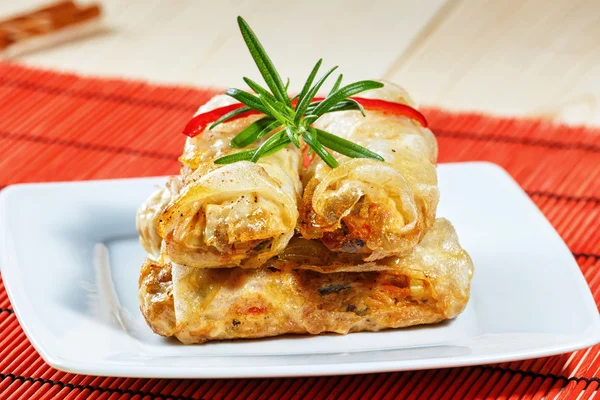 Rollos fritos de primavera en alfombra de bambú rojo — Foto de Stock