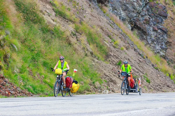 Fagaras Mountains, Romania - JULY 21, 2014: Unidentified cuple of cyclists going to road in Fagaras Mountain, Romania. Cycling is one of the most popular adventure sports in the world — Stock Photo, Image