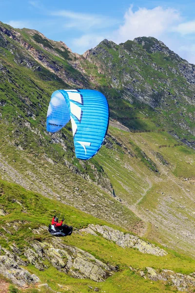 Balea lake, Rumänien - 21. Juli 2014: Unbekannter Gleitschirmflieger in balea lake, fagaras mountain, Rumänien. Paragliding ist eine der beliebtesten Abenteuersportarten der Welt — Stockfoto