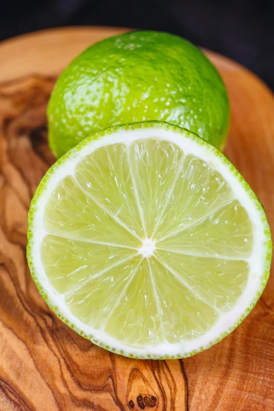 Limones verdes en la mesa de madera — Foto de Stock