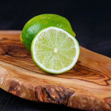 ahşap masa üzerinde yeşil limon