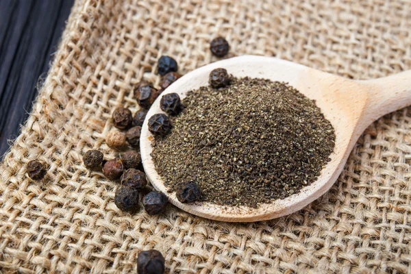 Black pepper on the wooden spoon — Stock Photo, Image