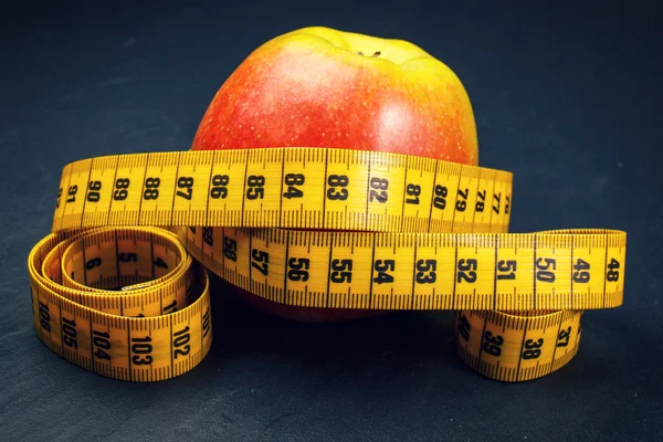 Apple with yellow measuring tape Royalty Free Stock Photos
