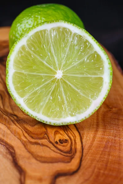 Limones verdes en la mesa de madera — Foto de Stock