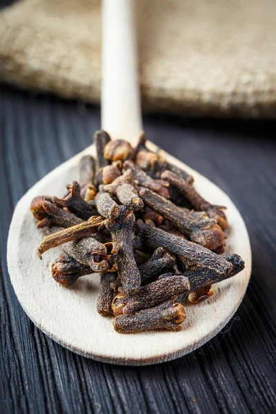 Pile cloves on wooden spoon — Stock Photo, Image