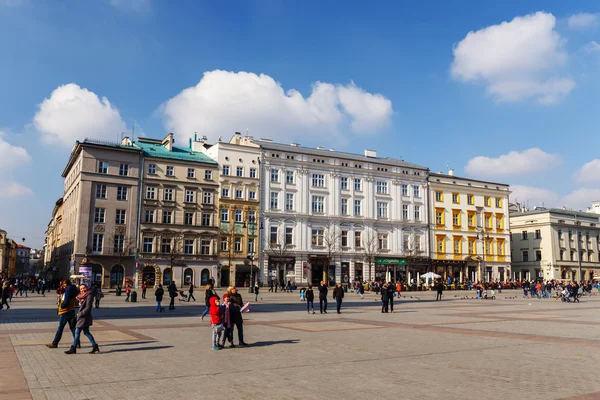 KRAKOW, POLOGNE - 07 mars 2015 : Des touristes non identifiés visitent la place principale du marché devant la basilique Sainte-Marie, à Cracovie, en Pologne, le 07 mars 2015. Vieille ville de Cracovie inscrite au patrimoine de l'Unesco — Photo